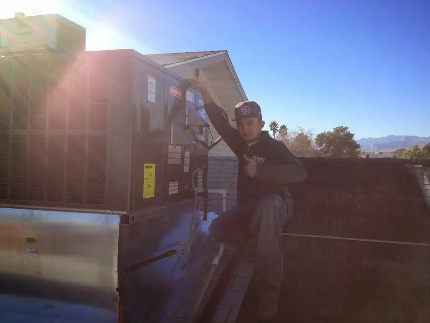HVAC technician performing Heat Pump Repair on a rooftop unit in Southold